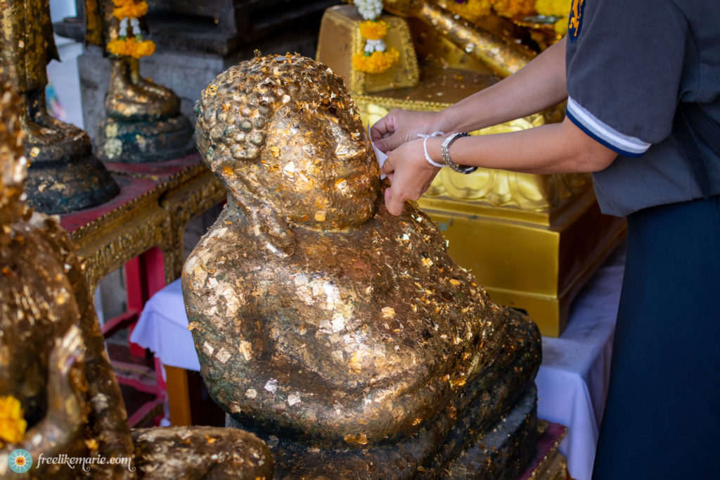 Putting Gold-Leaf on a Buddha Statue in Thailand